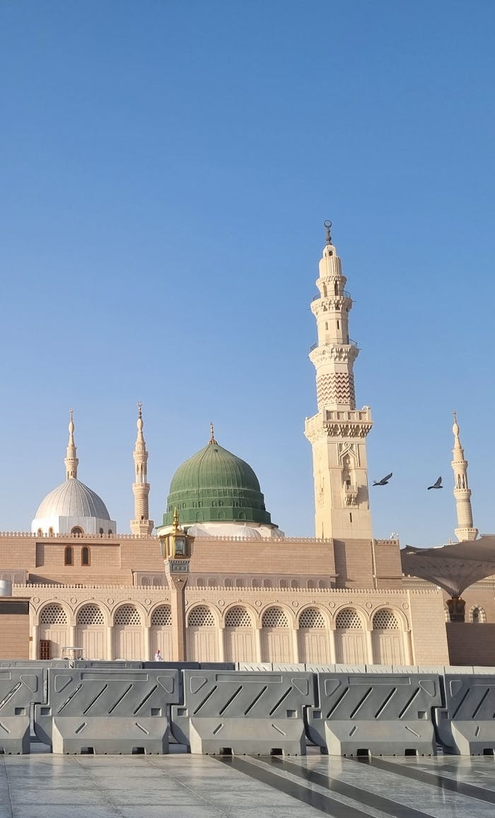 Stunning view of the Green Dome at Al-Masjid an-Nabawi, Medina, under a clear blue sky.